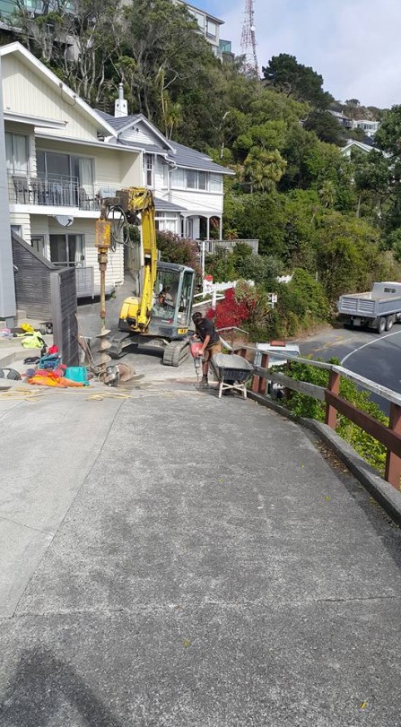 Drilling holes to strength a driveway.