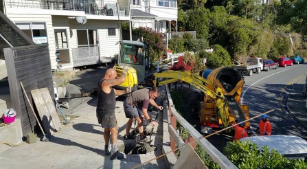 Drilling holes to strength a driveway.